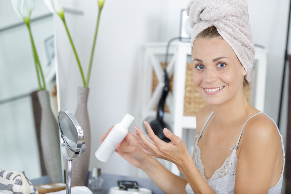 woman with towel on head applying it on hand