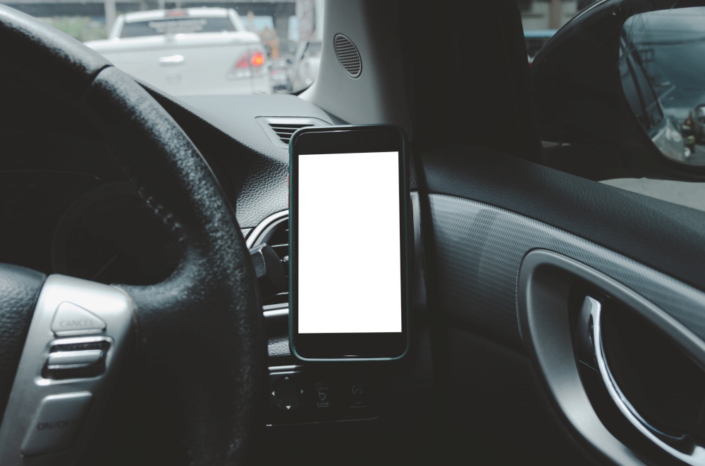 Mobile phone on the car air vent.Blank with white screen.Mock up smart phone in car.