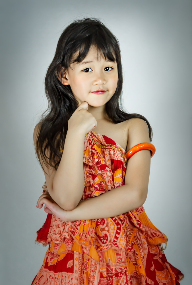 Portrait of asian little  girl in orange dress. portrait of asian little  girl