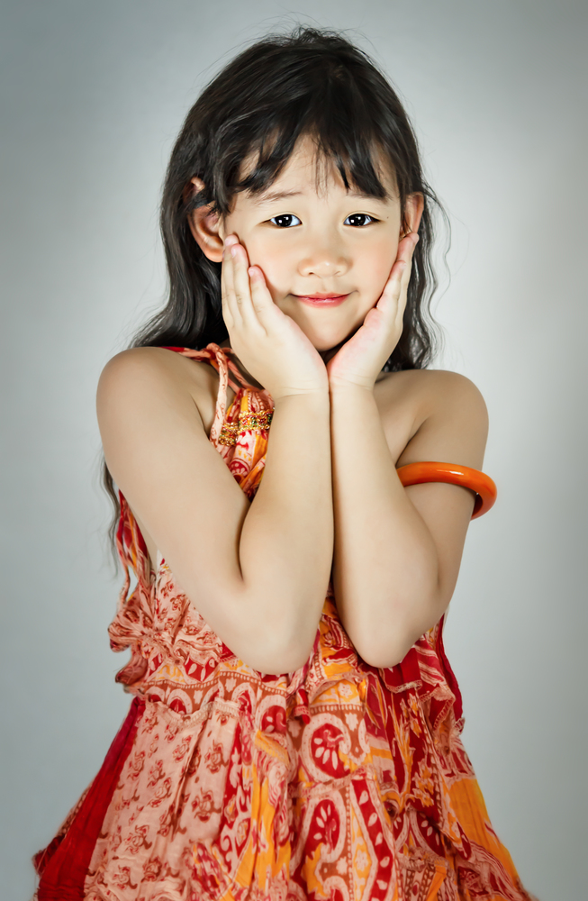 Portrait of asian little  girl in orange dress. portrait of asian little  girl
