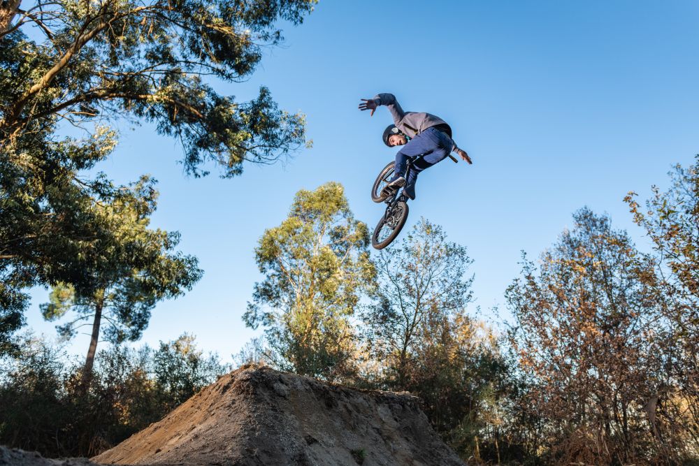 BMX Bike jump over a dirt trail on a dirt track.