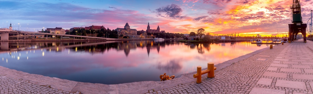 Picturesque panoramic view of the embankment and the old city at sunrise. Szczecin. Pomerania. Poland.. Szczecin. City embankment in the historical part of the city at dawn.