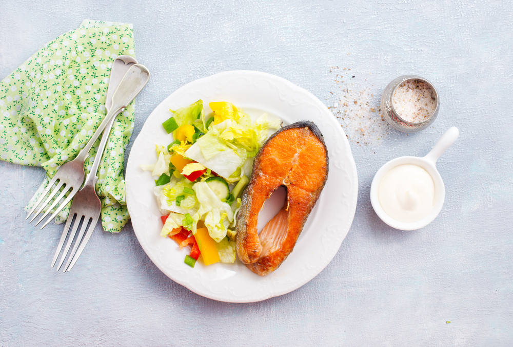 fried salmon with fresh salad on plate