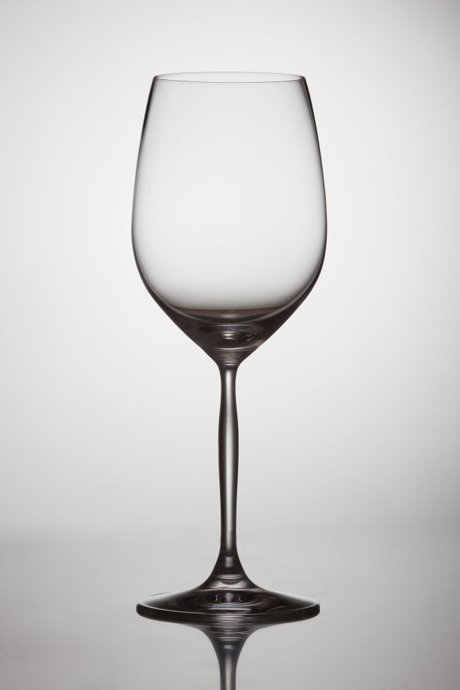 empty transparent wine glass on a table on a white background. Wine glass on white background