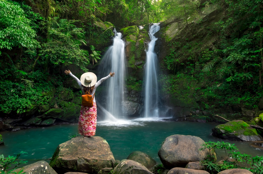 Rear view of young woman in front of Sapan Waterfall, Khun Nan National Park, Boklua District, Nan Province, Thailand.. Sapan waterfall