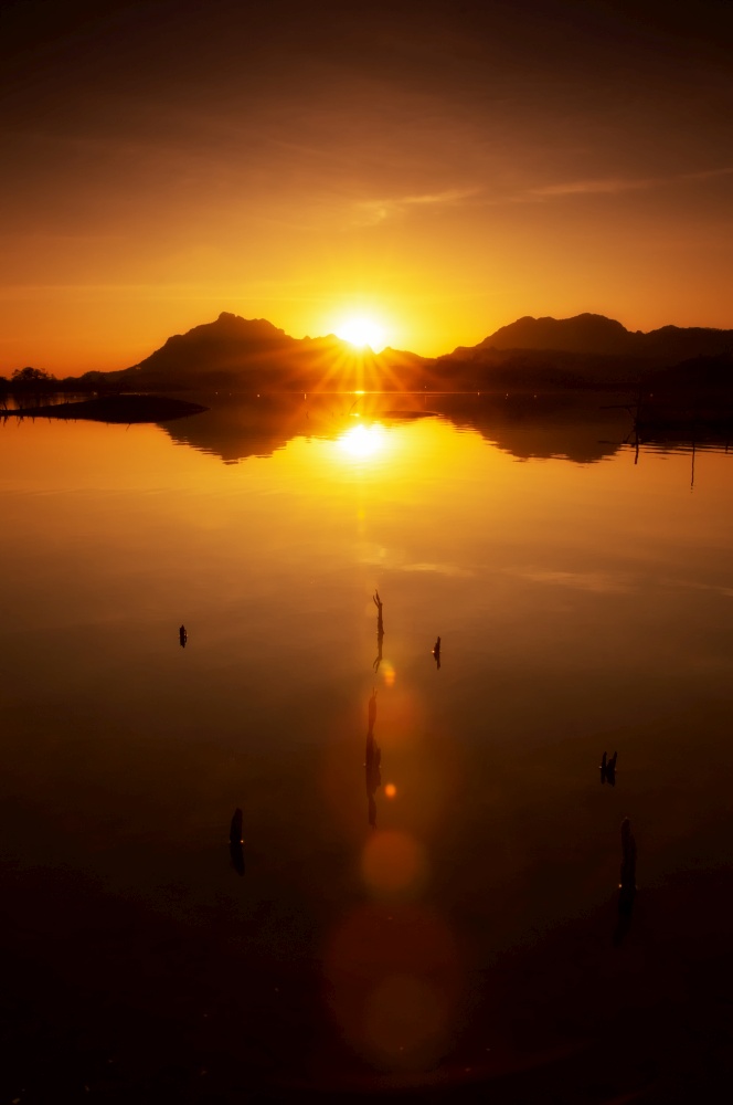 Beautiful Scenic Sunset Landscape, Sunbeam over Mountain with lens flare at Nasak Lake Mae Moh Lampang in thailand.. Sunset Nasak Lake.