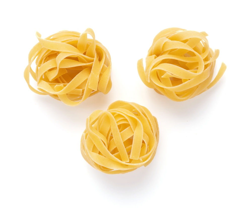 Pasta tagliatelle isolated on white background. Raw tagliatelle italian food at white