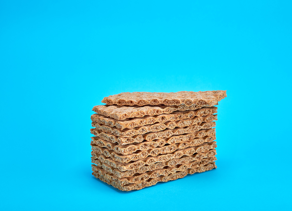 A stack of rectangular snack bars on a blue background, copy space