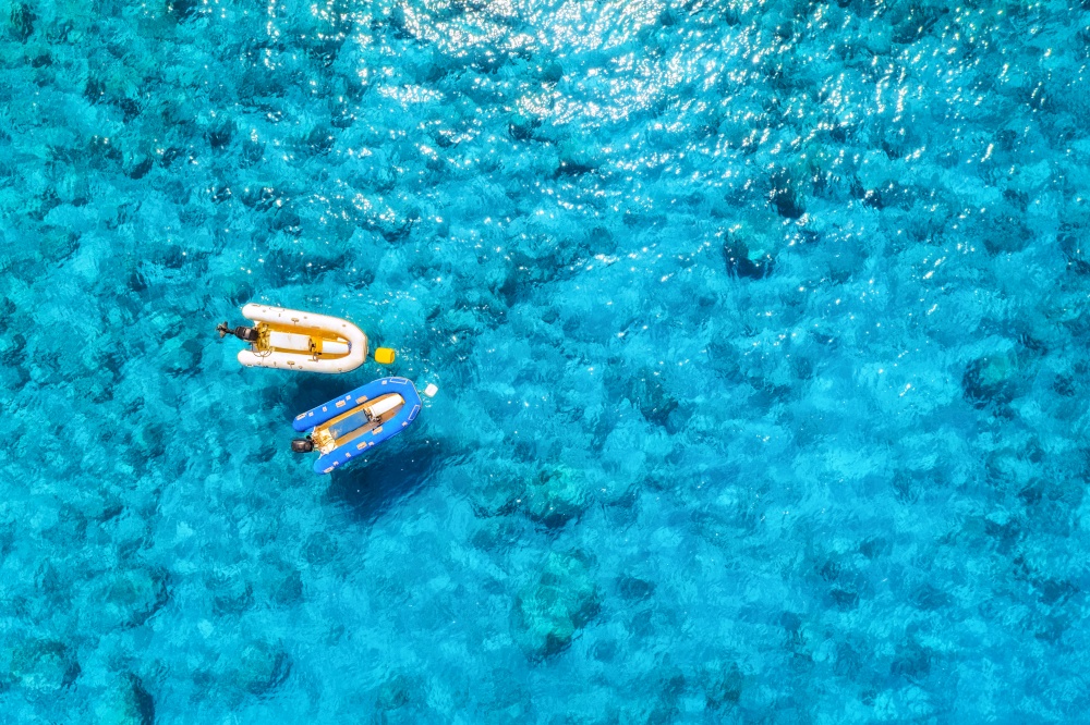 Aerial view of the boats in clear blue water at sunny day in summer. Top view from drone of yacht, sandy beach in mediterranean sea. Travel in Oludeniz, Turkey. Tropical landscape with motorboat