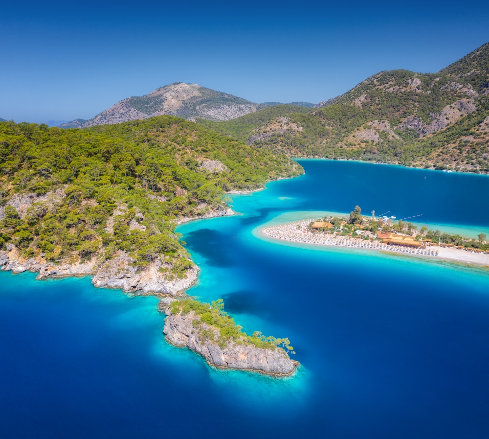 Aerial view of sea bay, rock, sandy beach, trees, mountain at sunny day in summer. Blue lagoon in Oludeniz, Turkey. Tropical landscape with island, white sandy bank, blue water. Top view. Nature