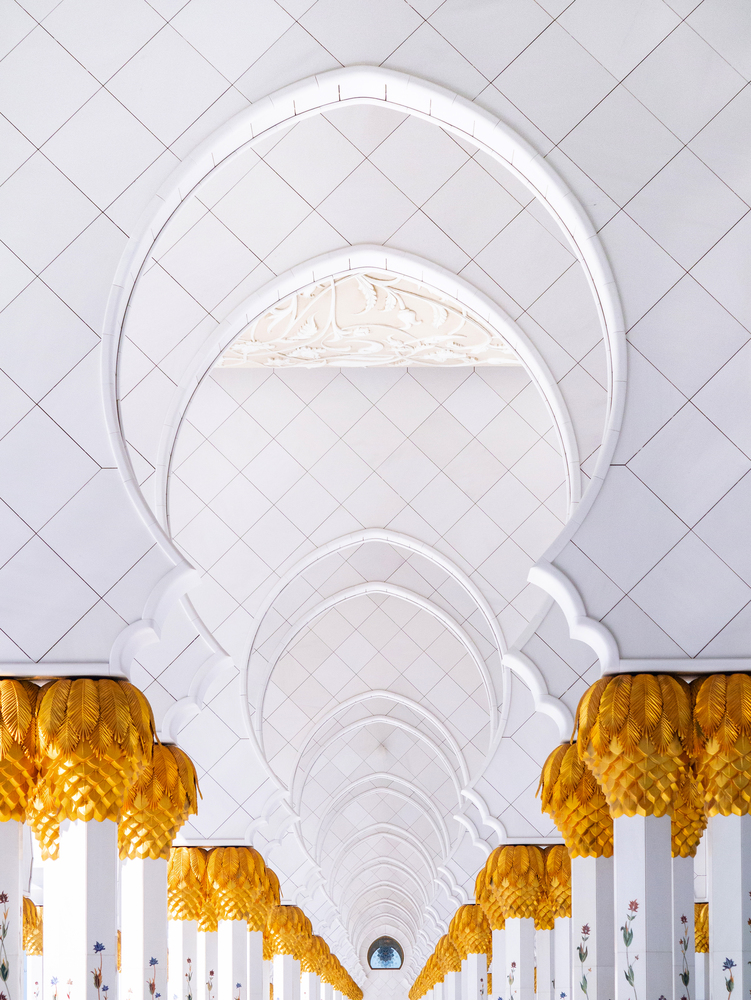 FEB 2, 2015 Abu Dhabi, UAE - White marble arch gates corridor with golden palm pillars of Sheikh Zayed Mosque, Grand mosque white marble architecture perspective