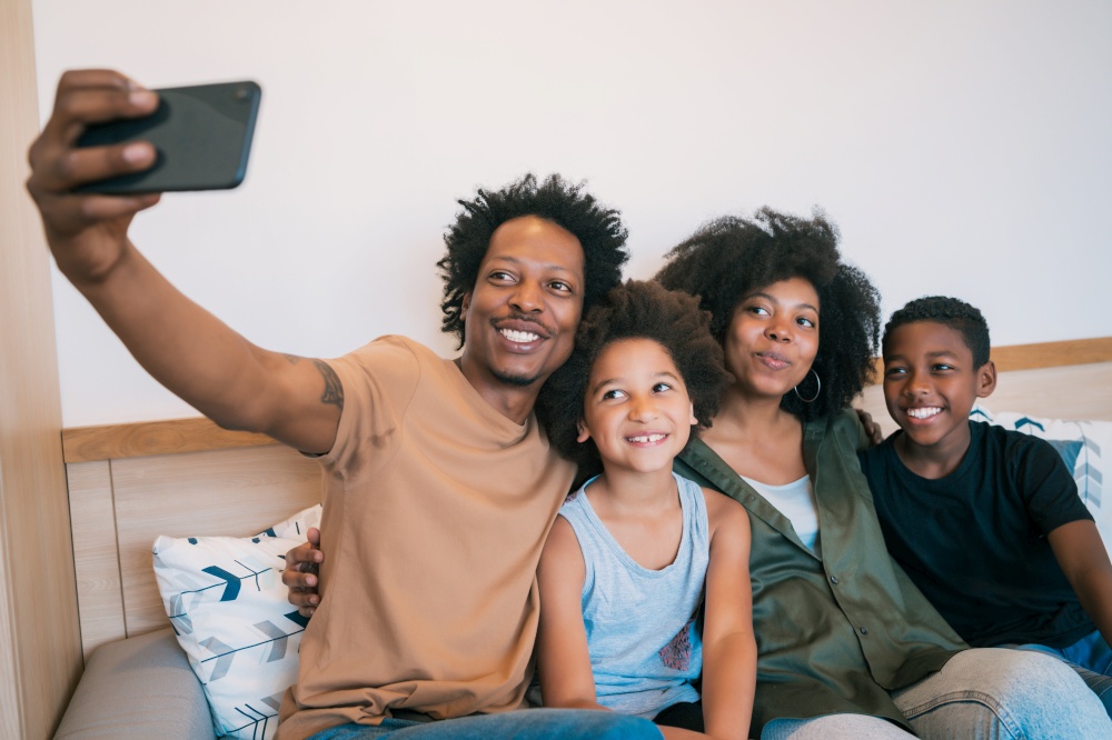 Portrait of African American family taking a selfie together with mobile phone at home. Family and lifestyle concept.. Family taking selfie together with phone at home.