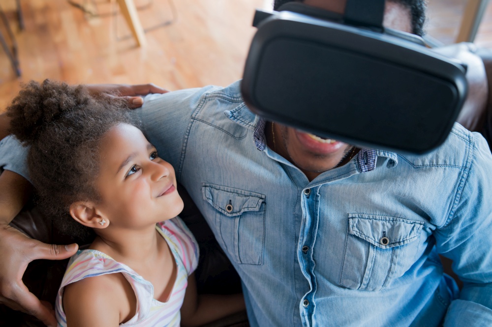 Portrait of a father and daughter playing video games with VR glasses while staying home. Monoparental concept. Stay home concept.