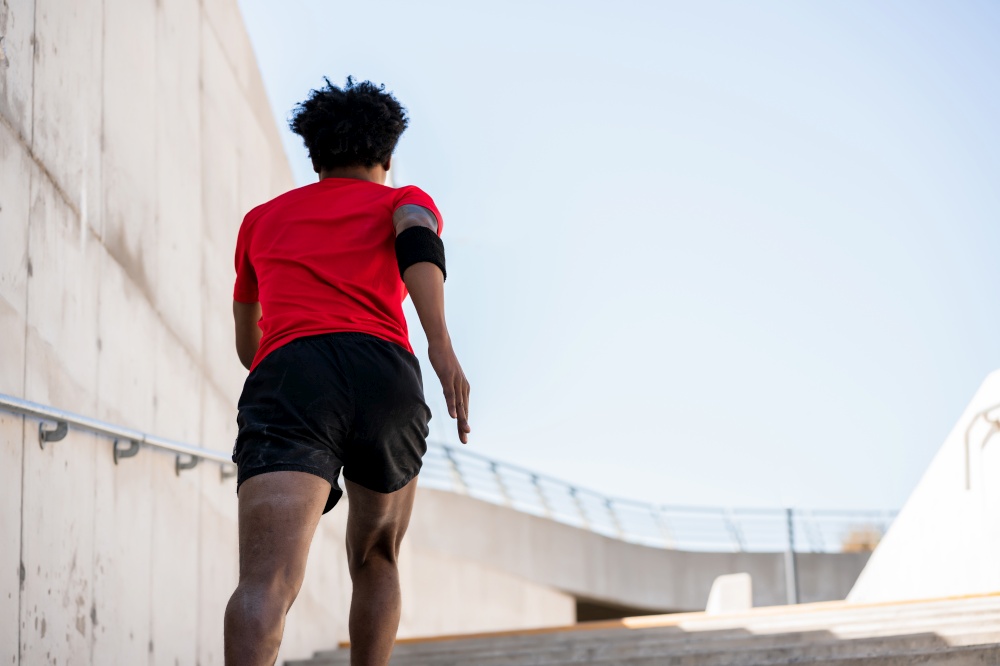 Portrait of afro athlete man running and doing exercise outdoors. Sport and healthy lifestyle.