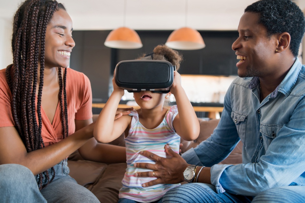 Portrait of a family spending time together and playing video games with VR glasses while staying home. New normal lifestye concept. Stay home.