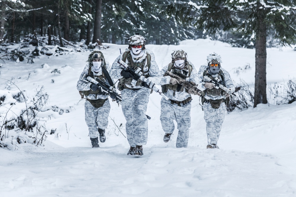 Winter arctic mountains warfare. Action in cold conditions. Squad of soldiers with weapons in forest somewhere above the Arctic Circle. Squad of soldiers in winter forest