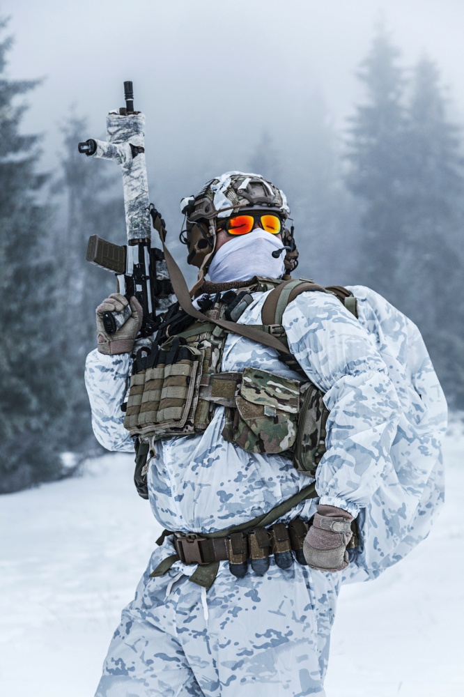 Winter arctic mountains warfare. Action in cold conditions. Trooper with weapons in forest somewhere above the Arctic Circle. Winter arctic warfare