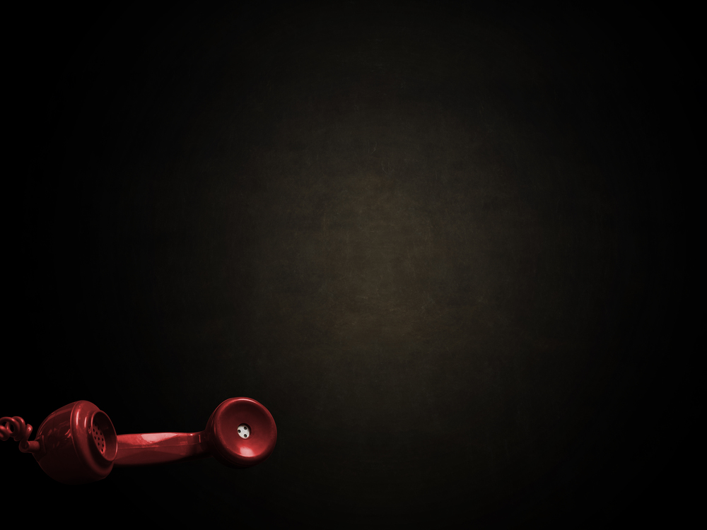 Retro red rotary phone headset on a textured black background with copy space and room for text