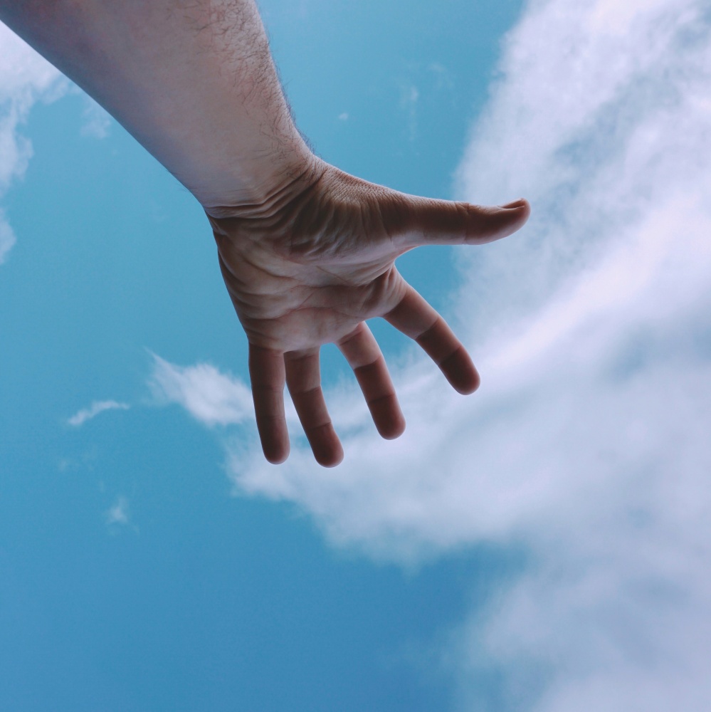 man hand gesturing and feeling the blue sky