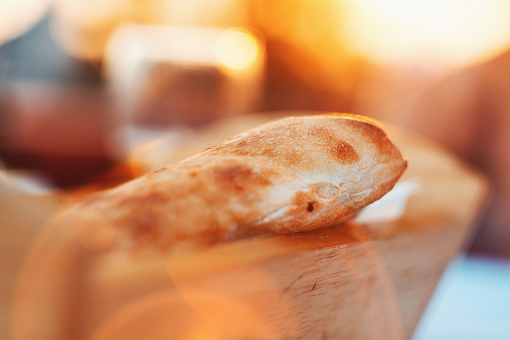 Oven Baked Homemade Traditional Bread In Wooden Basket In Sunlight During Sunset