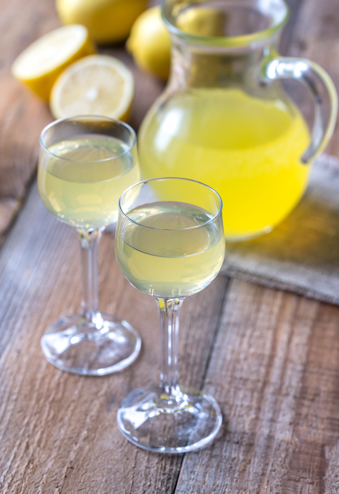 Two glasses of limoncello on the wooden background