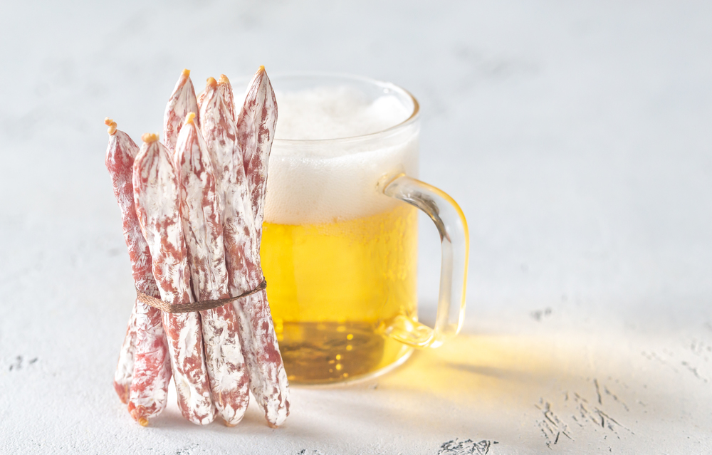 Snack fuet sausages with glass mug of beer