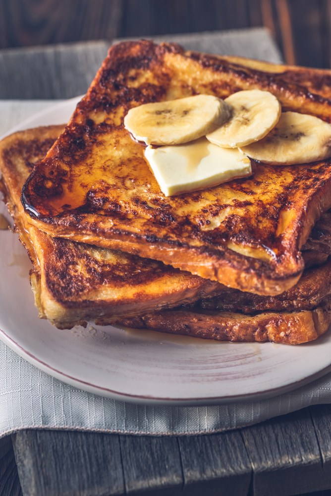 French toast with butter, sliced banana and maple syrup