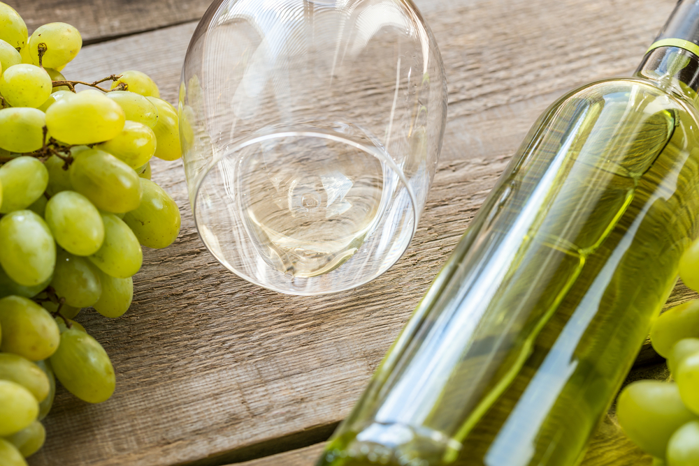 Bottle of white wine with bunch of grape
