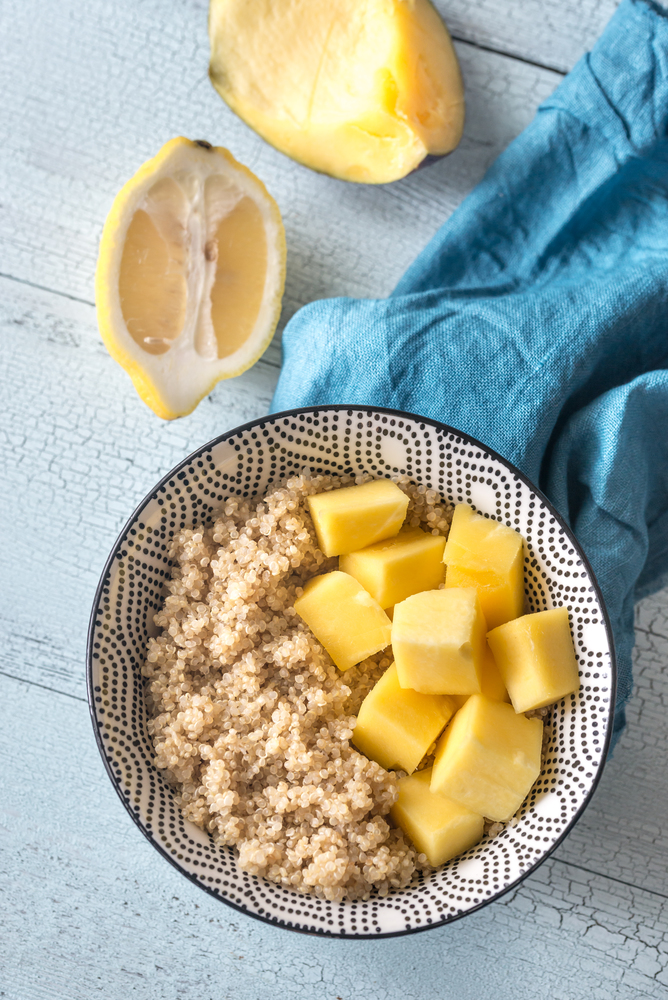 Portion of cooked quinoa with mango slices
