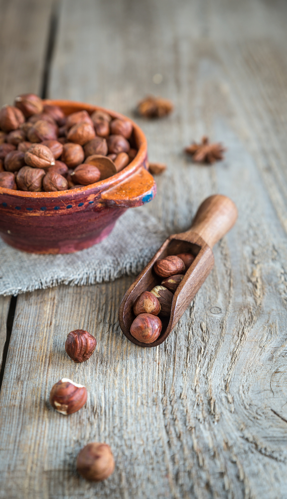Bowl of hazelnuts on the wooden board