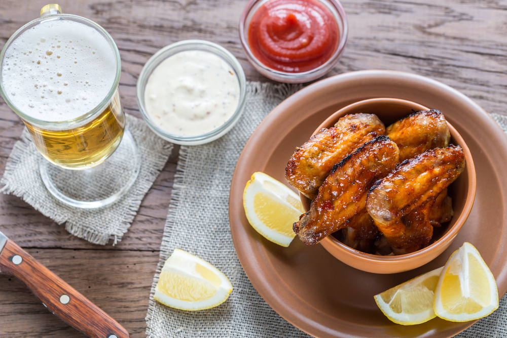 Caramelized chicken wings with glass of beer