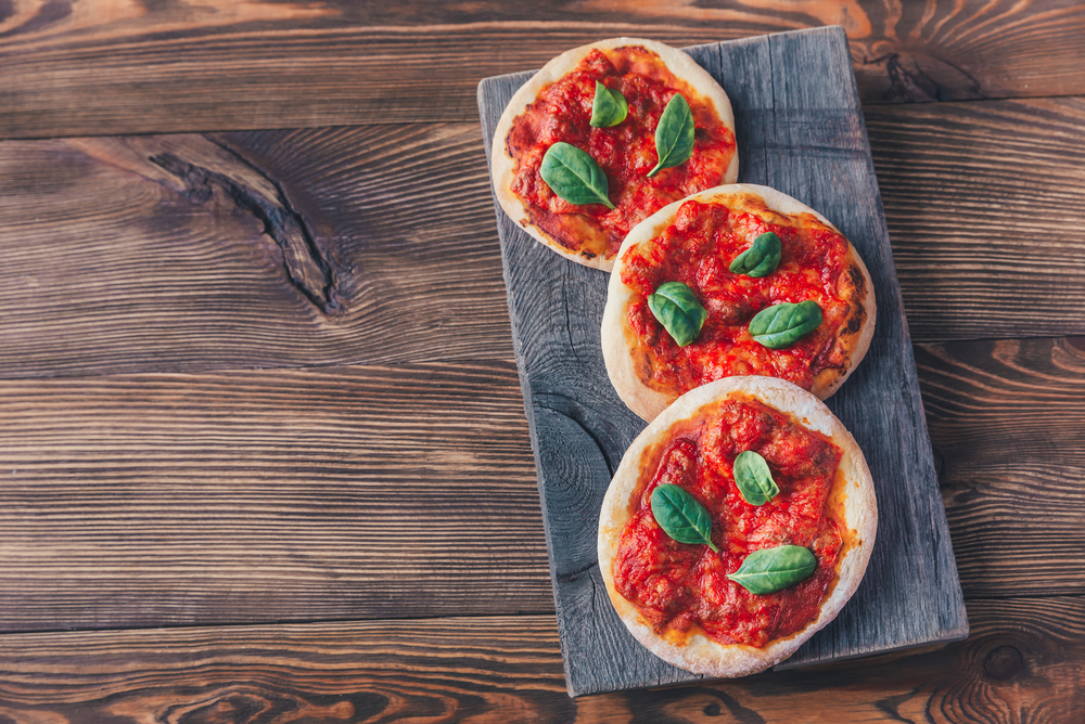 Mini Margherita pizzas with red cheese on the wooden board