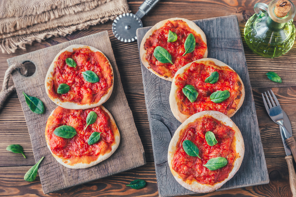 Mini Margherita pizzas with red cheese on the wooden board