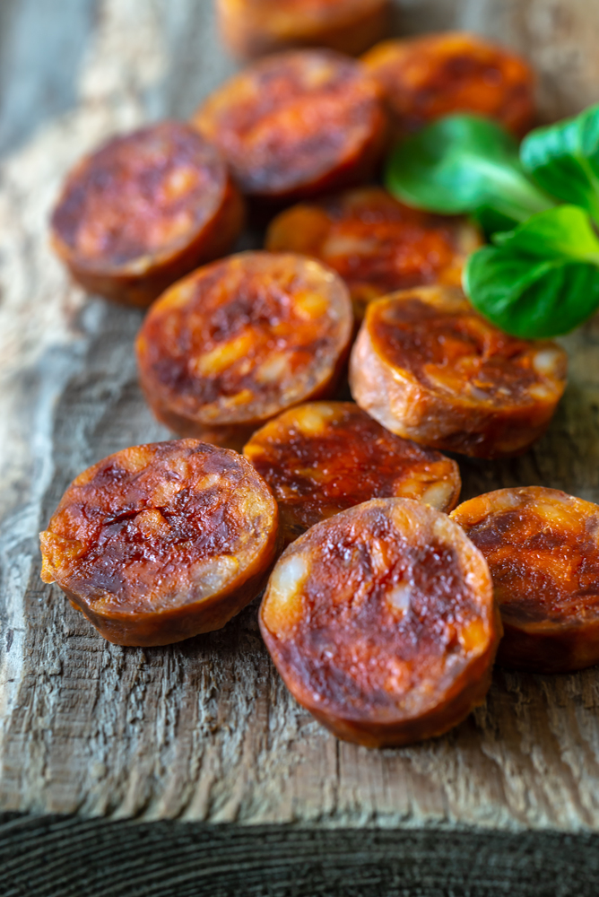 Slices of with spanish chorizo on the wooden board