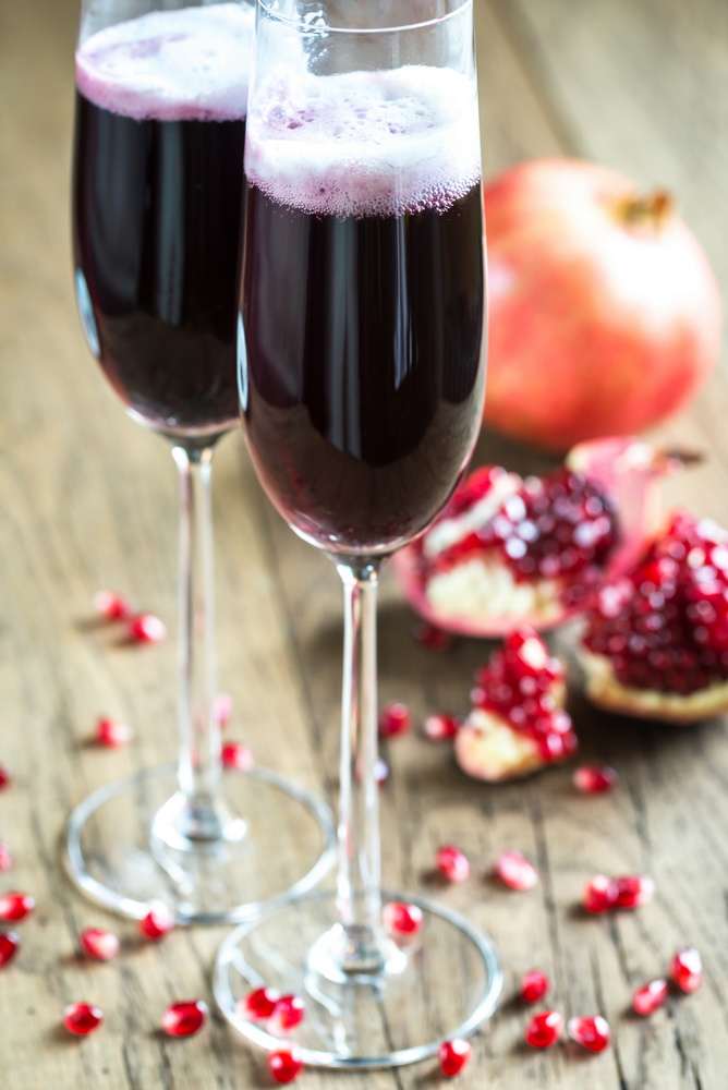 Two glasses of champagne with pomegranate seeds
