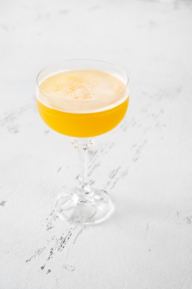 Glass of Algonquin cocktail on white wooden background
