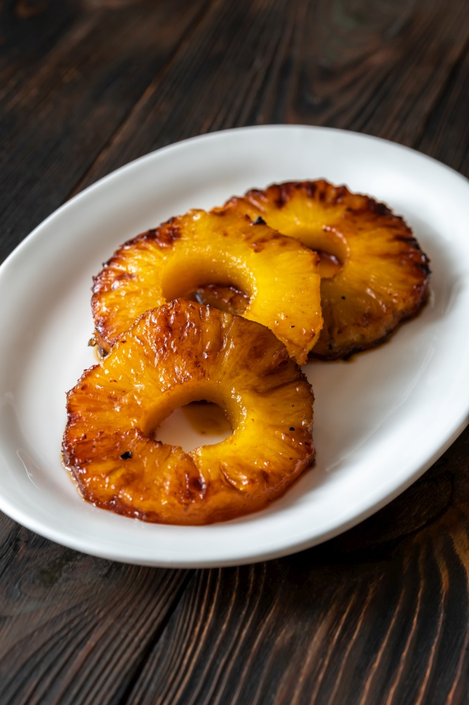 Slices od roasted caramelized pineapple on the serving plate