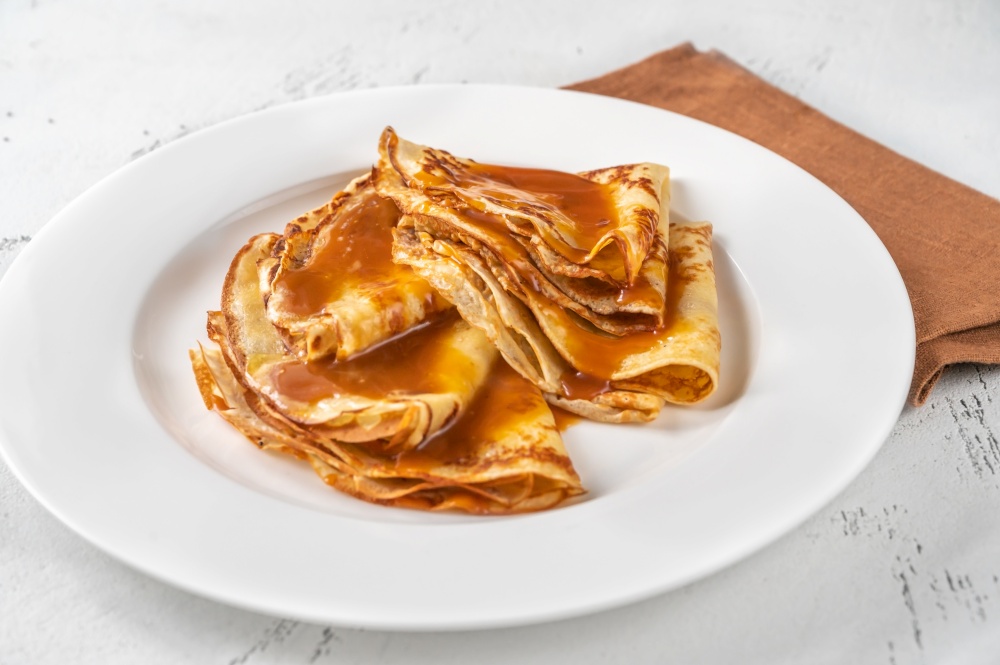 Stack of homemade crepes topped with caramel