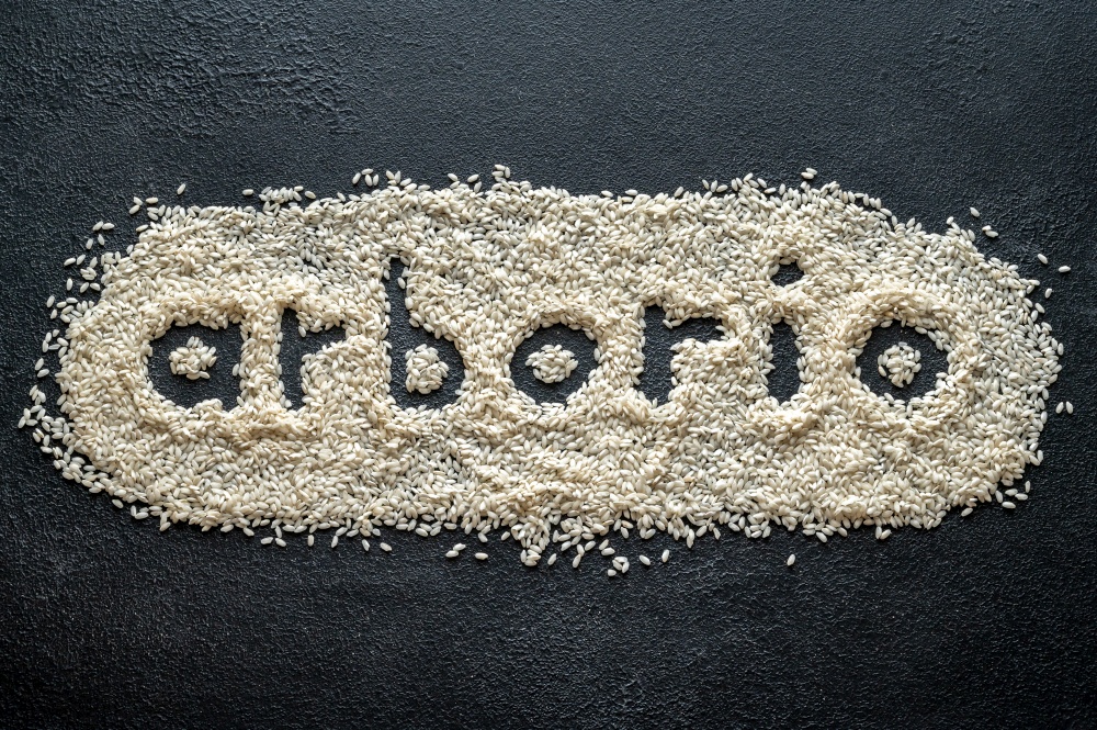 Uncooked arborio rice on the wooden background