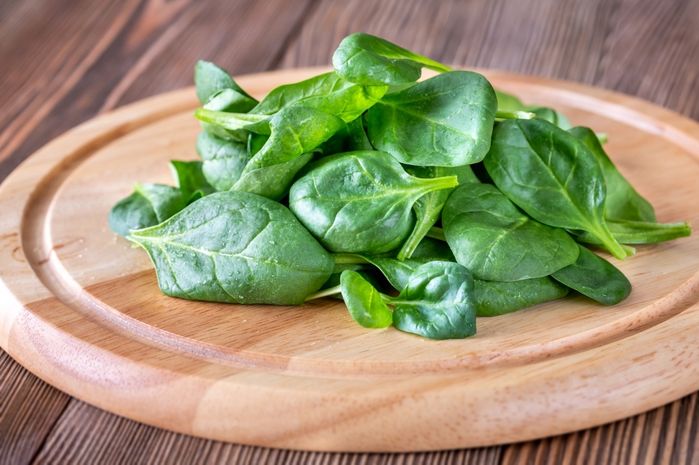 Leaves of fresh spinach on the wooden board