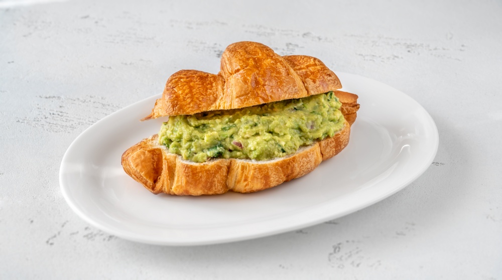 Croissant with guacamole on the serving plate