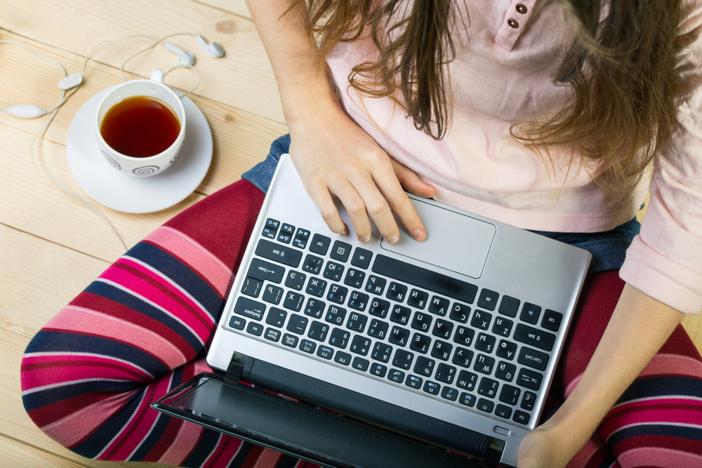 Teen girl sitting with a laptop