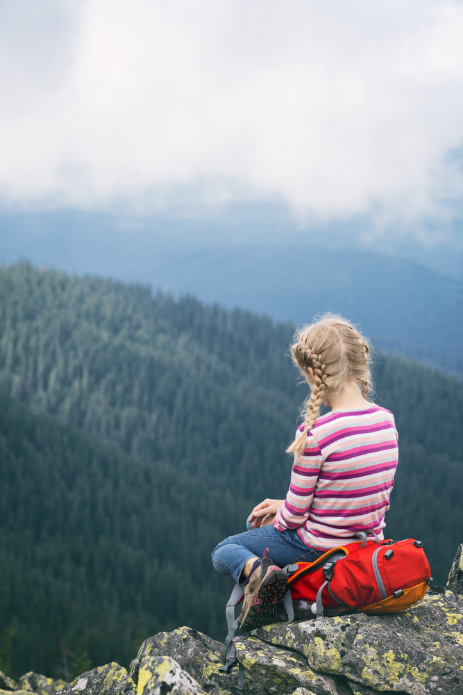 little tourist girl and mountain landscape