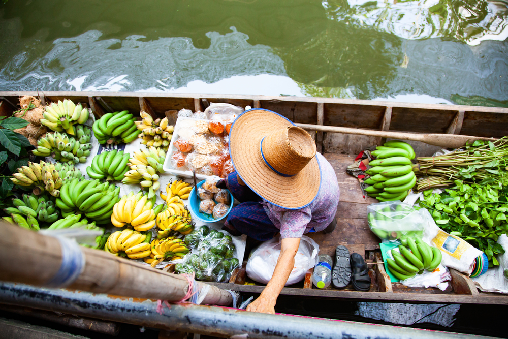 floating market - top view of boat full of fresh fruits on sale