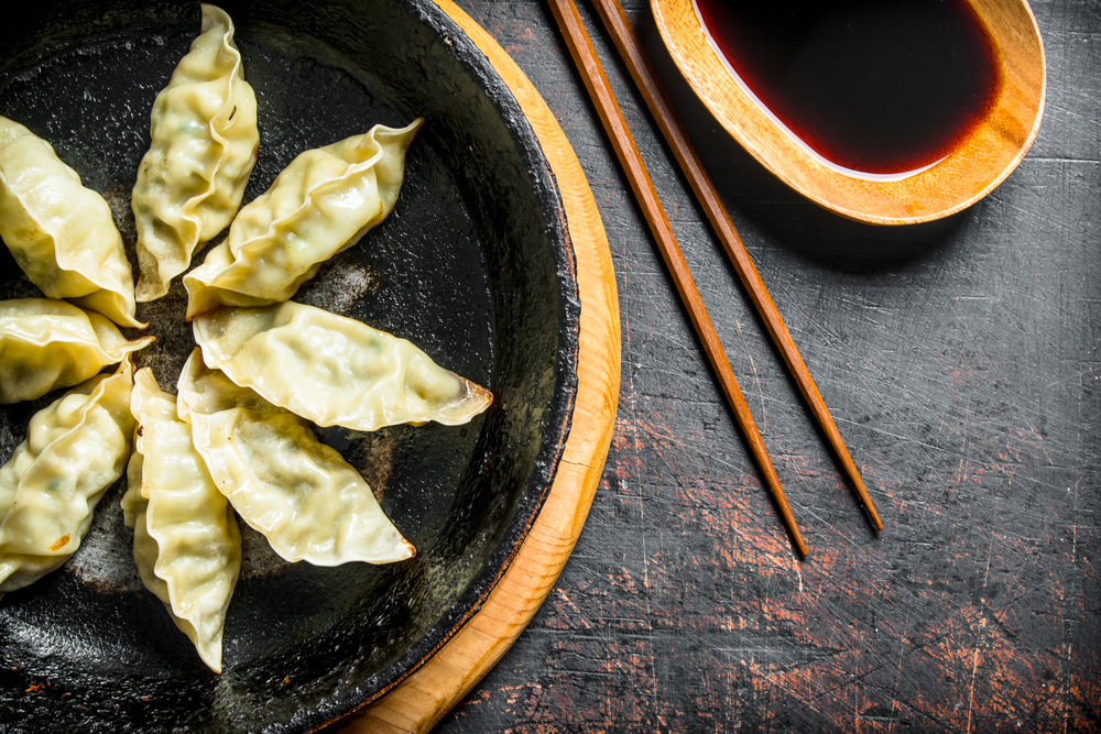 Fragrant Chinese gedza dumplings with meat. On dark rustic background. Fragrant Chinese gedza dumplings with meat.