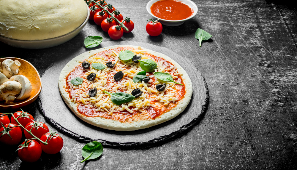 Preparation pizza. Dough with various ingredients for cooking pizza. On dark rustic background. Preparation pizza. Dough with various ingredients for cooking pizza.