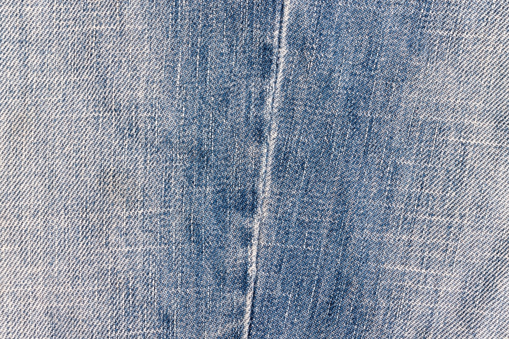 Indigo denim wallpaper. Grunge jeans background. Close-up old canvas surface. Fabric macro backdrop. Indigo denim wallpaper. Grunge jeans background.