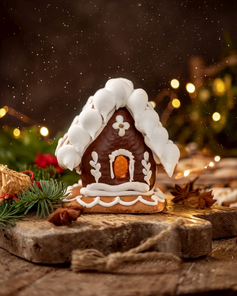 Gingerbread house on a rustic table with Christmas decoration