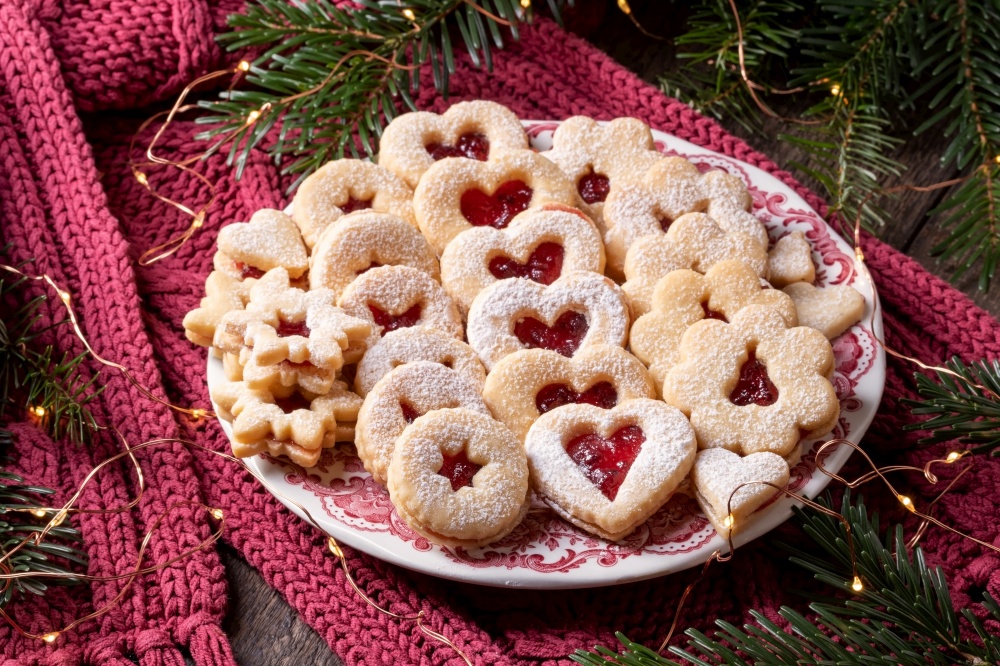Traditional Linzer Christmas cookies filled with marmalade arranged on a plate
