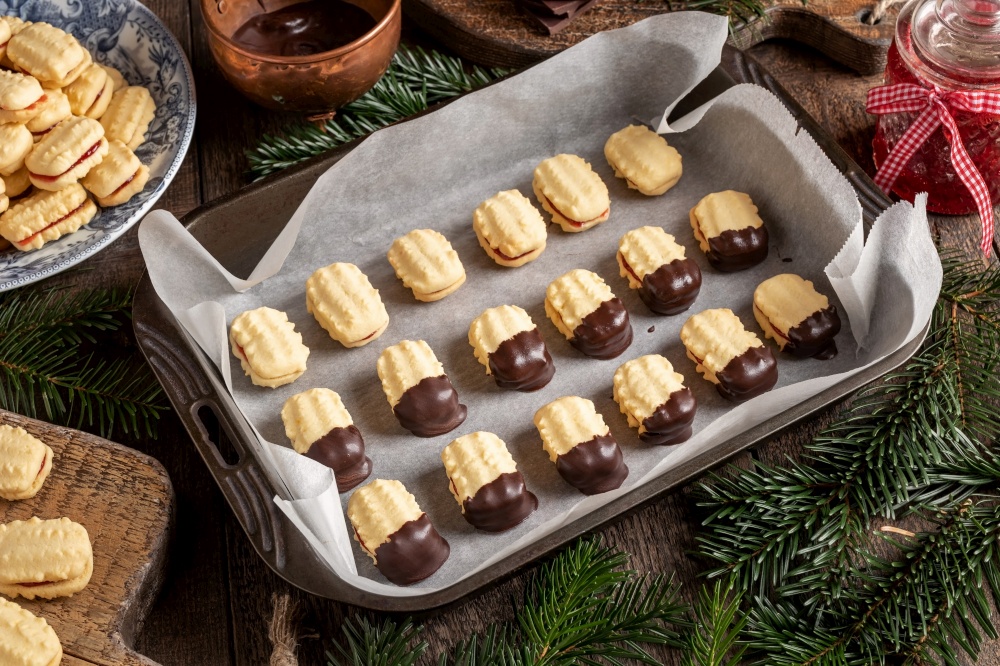 Preparation of Christmas cookies filled with marmalade and dipped in chocolate